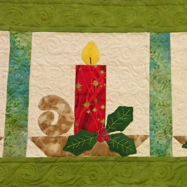 Appliqué candle table runner with holly, quilted by Rhoda